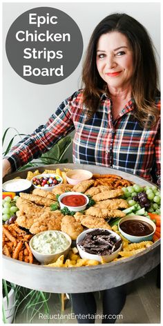 a woman holding a platter full of chicken strips