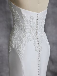 the back of a wedding dress with beading on it