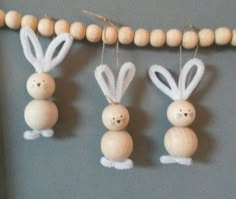 three wooden bunnies hanging from a string