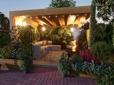 an outdoor living area is lit up at night with lights on the ceiling and potted plants in the foreground