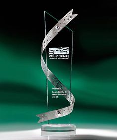 a glass award with a silver ribbon around it's neck and an arrow in the center