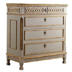 an antique chest of drawers with gold trimmings