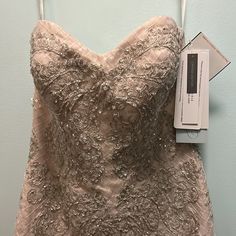 a dress hanging on a hanger next to a box with the label in it