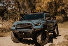 a blue truck driving down a dirt road