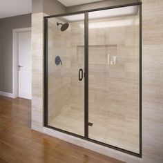 a bathroom with a walk in shower next to a white wall and wooden flooring