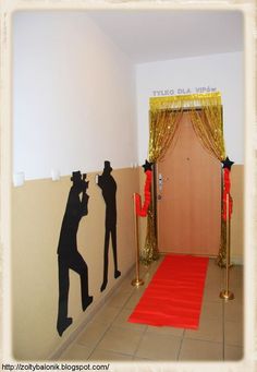 a room with a red carpet and two black silhouettes on the wall next to a doorway