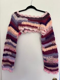 a crocheted sweater hanging on a door