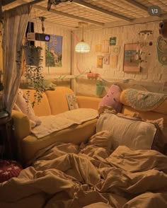 an unmade bed with lots of pillows and blankets on it in a small room