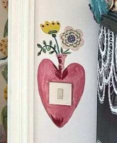 a heart shaped light switch cover with flowers on it