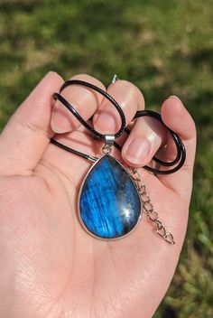 "These beautiful labradorite teardrop pendants have gorgeous blue flash on both sides. Each pendant measures about 1.5 inches long by 1 inch wide.  They come strung on a black cord necklace that is 17\" long with a 2\" extender.  These are natural stones, so please understand there may be slight flaws. ----- About us: We are a couple of besties sharing our mutual loves of bones, crystals, and plants. Everything in the shop is either handmade or hand-selected with intent.  We do not use filters on any of our photos! We do choose the lighting (indoor, outdoor, time of day) that will highlight the item best, but everything we photograph is taken without filters, and will be clearly labeled as to whether you are getting this exact item or a similar one (in case of plants or crystals) We ship o Adjustable Teardrop Crystal Necklace, Adjustable Blue Teardrop Drop Necklace, Adjustable Teardrop Blue Drop Necklace, Handmade Clay Jewelry, Cord Necklace, Crystal Items, Clay Jewelry, Bead Charms, Labradorite