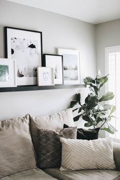 a living room filled with lots of furniture and pictures on the wall above it's couch