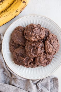 a white plate topped with chocolate cookies next to a banana