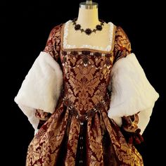 This Tudor style ensemble is perfect for your next Ren Faire, Theatre production, Larp, or any other event! Included is the outer gown, underskirt, and fore sleeves. The outer gown is made in a beautiful burgundy brocade with fur accented sleeves, and laces up in the back for a perfect fit. It is fully lined on the bodice part, and the skirt has clean finished seams. The fore sleeves are removable and made in a matching brocade and satin. Underskirt is full (made with almost 10 yards of fabric!) Tudor Dress Aesthetic, Historical Brocade Dresses For Costume Party, Fitted Historical Design Floor-length Ball Gown, Floor-length Fitted Ball Gown With Historical Design, Fitted Floor-length Ball Gown With Historical Design, Fitted Brocade Ball Gown, Historical Design Fitted Floor-length Ball Gown, Fitted Brocade Ball Gown Dresses, Fitted Brocade Dress For Costume Party