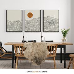 a dining room table with chairs and two paintings on the wall above it that have mountains in them