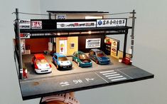 a toy car garage with cars on the roof and in front of it's doors