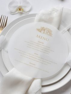 a white plate topped with a menu next to a fork and knife on top of a table