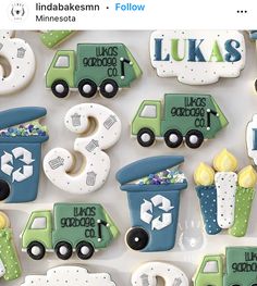 decorated cookies in the shape of trucks and recycling bins are displayed on a white surface