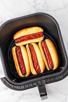 four hot dogs on buns in an air fryer