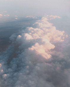 the view from an airplane looking down at clouds