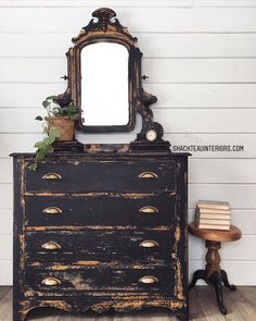 an old dresser with a mirror on top and a plant growing out of it's drawer