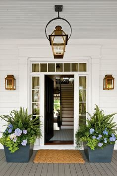 the front door is decorated with potted plants