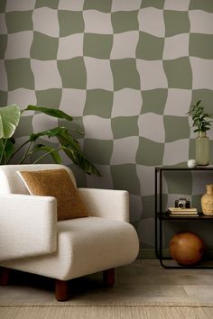 a white chair sitting in front of a wall with green checkered pattern on it