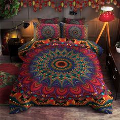 a bed covered in a colorful comforter next to a night stand