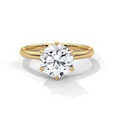 a yellow gold engagement ring with a round cut diamond in the center, on a white background