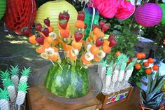 there are many fruits and vegetables in the vase on display for everyone to enjoy them