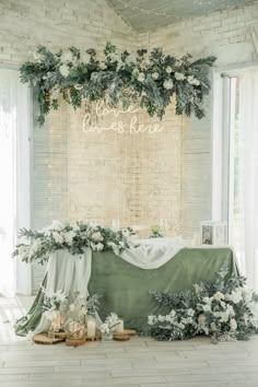 a table with flowers and greenery on it in front of a sign that says live & love