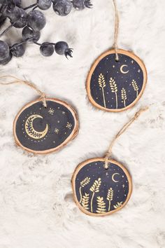 two wooden ornaments hanging from twine on white fur