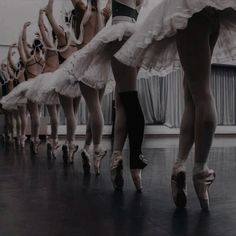 a group of ballerinas standing in a line with their feet on the floor