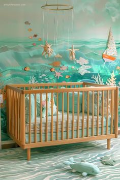 a baby's room decorated in blue and green with an ocean theme on the wall