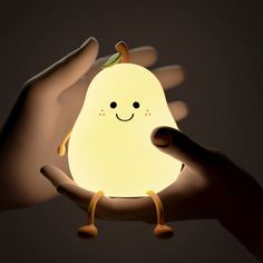 a person holding a small light in their hand with a smile on it's face