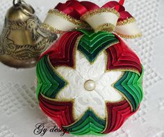 a christmas ornament with a red, green and white star on it next to a bell