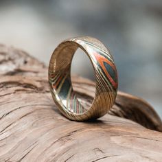 a wooden ring sitting on top of a piece of wood