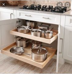 an open cabinet with pots and pans on it