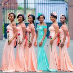 a group of women standing next to each other wearing dresses and head wraps on their heads