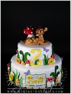 a birthday cake with the number two on it and a deer figurine sitting on top