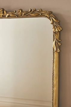 a gold framed mirror sitting on top of a table