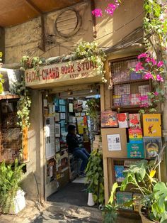 a store with lots of books and plants on the side of it's door