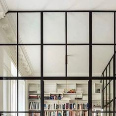 the interior of a home with large windows and bookshelves in it's center