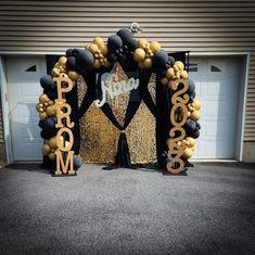 a black and gold balloon arch decorated with balloons