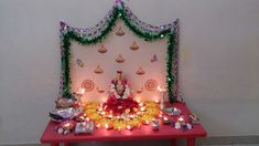 there is a small shrine with candles and decorations on the table in front of it