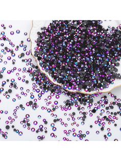 purple and black beads on a white surface