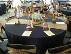 the tables are set up with black linens and brown bows