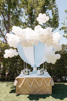 a table topped with balloons in the shape of a hot air balloon