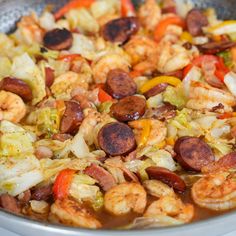 a pan filled with shrimp and vegetables on top of a stove