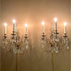 two wall sconces with candles attached to them