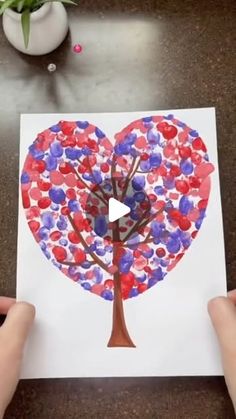 someone is holding up a heart shaped tree with red, white and blue hearts on it